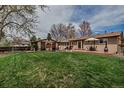 Spacious backyard with a well-maintained lawn and a brick patio, perfect for outdoor gatherings at 3630 W Saratoga Ave, Littleton, CO 80123