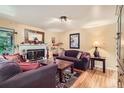 Cozy living room with a fireplace, hardwood floors, and comfortable seating at 6940 W 63Rd Ave, Arvada, CO 80003