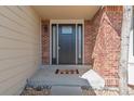 Inviting front porch with brick accents, a modern front door, and a welcoming mat at 1919 Breen Ln, Superior, CO 80027