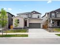 Charming two-story home showcasing a gray brick facade, attached two-car garage, and a well-manicured lawn at 547 Homestead Ave, Brighton, CO 80601