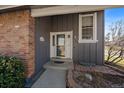 Inviting home entrance with a white framed door, brick facade, and well-kept stone landscaping at 8699 Garrison Ct, Arvada, CO 80005