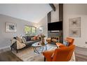 Cozy living room featuring a brick fireplace, vaulted ceilings, and ample natural light at 8699 Garrison Ct, Arvada, CO 80005