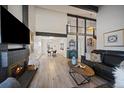 Open-concept living room with vaulted ceilings, sleek hardwood floors, and a cozy fireplace at 8699 Garrison Ct, Arvada, CO 80005