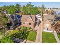 An aerial view of a well-maintained brick home with lush landscaping and a brick driveway at 1528 Holly St, Denver, CO 80220