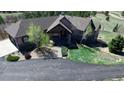 This high angle shows this home's attractive landscaping, including mature trees and a circular driveway at 12984 Crowfoot Springs Rd, Larkspur, CO 80118