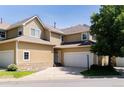 Exterior of a tan townhome with a two-car garage, stone accents and a well-maintained lawn at 211 Rockview Dr, Superior, CO 80027