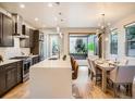 Modern kitchen and dining area featuring an island with seating, pendant lighting, and stainless steel appliances at 4535 Stuart St, Denver, CO 80212