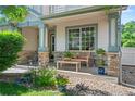 Charming front porch with stone pillars, cozy seating, and decorative plants offers a welcoming entrance at 6808 Silverleaf Ave, Firestone, CO 80504