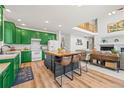 Open-concept kitchen featuring colorful cabinetry, a butcher block island, and seamless flow to the living area at 6808 Silverleaf Ave, Firestone, CO 80504
