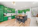 Bright kitchen with bold green cabinets, butcher block island, and modern appliances at 6808 Silverleaf Ave, Firestone, CO 80504