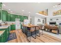 Bright kitchen features green cabinetry, white appliances, and an island with seating for three at 6808 Silverleaf Ave, Firestone, CO 80504