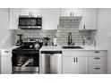 Modern kitchen featuring stainless steel appliances and white cabinets at 5570 Otis Ct, Arvada, CO 80002
