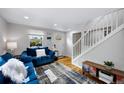 Cozy living room with hardwood floors and an open staircase with white risers at 5570 Otis Ct, Arvada, CO 80002