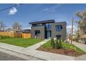 Contemporary two-story home showcasing a manicured lawn and sleek architectural design with a gray facade at 1459 W 42Nd Ave, Denver, CO 80211