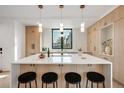 Modern kitchen featuring a large island with seating and stylish pendant lighting over white countertops at 1459 W 42Nd Ave, Denver, CO 80211