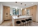 Modern kitchen featuring a large island with seating and stylish pendant lighting over white countertops at 1459 W 42Nd Ave, Denver, CO 80211