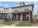 Inviting two-story home with a covered front porch and a brick facade in a Gathering-friendly neighborhood at 21204 E 63Rd Dr, Aurora, CO 80019