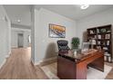 Home office featuring a large wooden desk, comfortable leather chair, and built-in bookshelf at 21204 E 63Rd Dr, Aurora, CO 80019