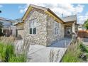 Attractive home with a stone facade and a well-maintained walkway leading to the front porch at 19677 E Vassar Dr, Aurora, CO 80013