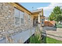 Beautiful home with stone exterior, complemented by well-kept landscaping and a welcoming walkway at 19677 E Vassar Dr, Aurora, CO 80013