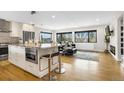 Bright living room and kitchen featuring modern white cabinets, granite countertops, and a view of the landscape at 597 Vista Dr, Castle Rock, CO 80104