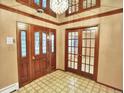 The foyer has tile floors, a chandelier and glass paneled interior and exterior doors at 12135 W Applewood Knolls Dr, Lakewood, CO 80215