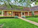 Charming front entrance with a covered porch, brick accents, and manicured lawn at 12135 W Applewood Knolls Dr, Lakewood, CO 80215