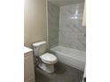 Cozy bathroom featuring a marble-tiled shower-tub combo and modern toilet at 14602 E 2Nd Ave # 108-C, Aurora, CO 80011