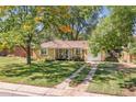 Well-kept single-story home with a manicured lawn and mature trees at 1755 Quince St, Denver, CO 80220