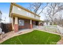 Charming home featuring a brick foundation and a spacious, well-maintained front lawn, surrounded by a white picket fence at 109 Cantril St, Castle Rock, CO 80104