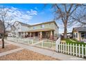 Inviting home with a brick foundation and charming front porch, enhanced by a classic white picket fence at 109 Cantril St, Castle Rock, CO 80104