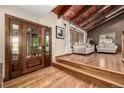 Welcoming foyer featuring hardwood floors, a wooden ceiling with beams, and a decorative front door at 6740 S Windermere St, Littleton, CO 80120