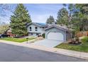 Charming two-story home with blue paint, well-manicured lawn, and integrated two-car garage at 3722 S Quebec St, Denver, CO 80237