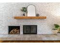 Modern fireplace with stylish brick, wooden mantle, and decorative accessories at 3722 S Quebec St, Denver, CO 80237