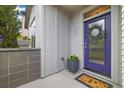 Inviting front entrance features a vibrant purple door, decorative wreath, and potted floral arrangements at 1882 W 67Th Ave, Denver, CO 80221