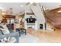 Bright living room boasts hardwood floors, exposed brick wall, modern furniture, and easy access to the kitchen at 428 S Grant St, Denver, CO 80209