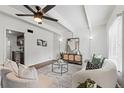 Bright living room featuring a modern sofa, accent chairs, stylish decor and adjacent kitchen view at 9725 E Harvard Ave # 323, Denver, CO 80231