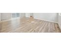 Spacious open-concept room featuring light hardwood floors and neutral wall paint at 7376 Watercress Dr, Littleton, CO 80125