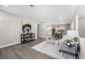 Bright, open living room with wood floors, modern decor, and seamless flow into the dining area at 914 Quari Ct, Aurora, CO 80011