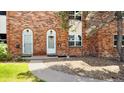 Brick townhouse exterior showcasing a walkway leading to two front doors with arched doorways at 3616 W Radcliff Ave, Denver, CO 80236