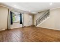 Inviting living room with hardwood floors, staircase, and large window for natural light at 3616 W Radcliff Ave, Denver, CO 80236