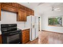 A kitchen featuring wooden cabinets, white appliances, and light-colored walls at 11196 E Baltic Dr, Aurora, CO 80014