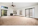 Bright living room featuring a fireplace, large windows, and a sliding glass door at 11196 E Baltic Dr, Aurora, CO 80014