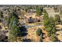 Aerial view of a charming estate featuring mature trees, tennis court, circular driveway, and well-maintained landscaping at 4181 S Colorado Blvd, Cherry Hills Village, CO 80113