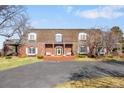 Charming brick home with arched windows, blue shutters, brick entryway, and circular driveway at 4181 S Colorado Blvd, Cherry Hills Village, CO 80113