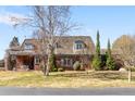 Beautiful home with manicured lawn, classic architecture, light shutters, and mature trees at 4181 S Colorado Blvd, Cherry Hills Village, CO 80113