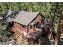 Aerial view showcasing the home's expansive deck, multiple seating areas, and private wooded surroundings at 20606 Yoke Trl, Morrison, CO 80465