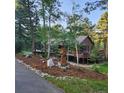 Beautifully landscaped yard with natural stone accents leading to a charming home with a spacious deck and an owl carving at 20606 Yoke Trl, Morrison, CO 80465