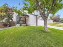 Well-maintained home featuring a charming front porch and green lawn at 9867 Mulberry Way, Highlands Ranch, CO 80129