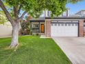 Inviting home with a well-maintained lawn, mature tree, and welcoming front porch at 9867 Mulberry Way, Highlands Ranch, CO 80129